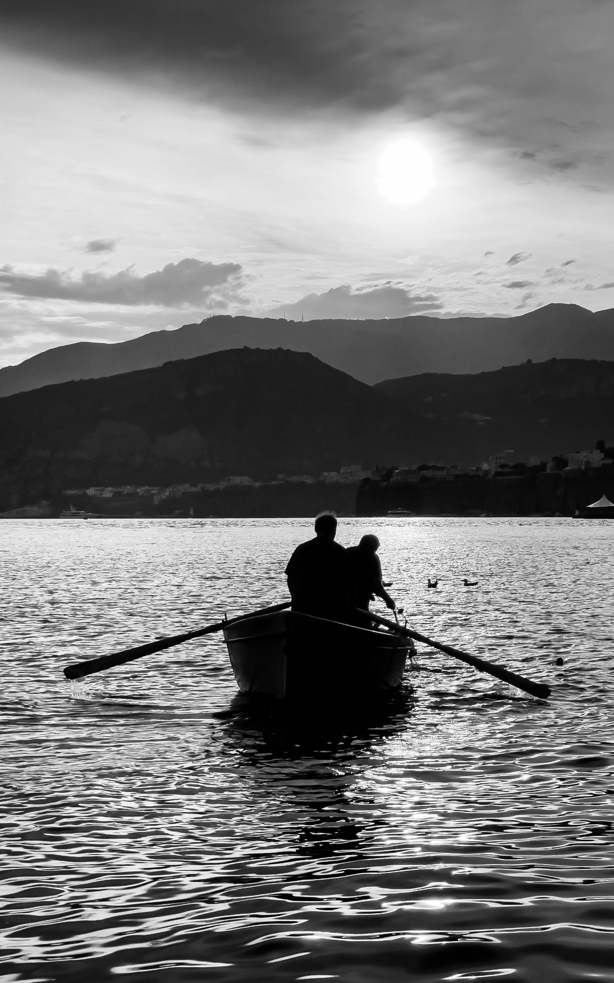 A fisherman rowing out of Sorrento at dusk